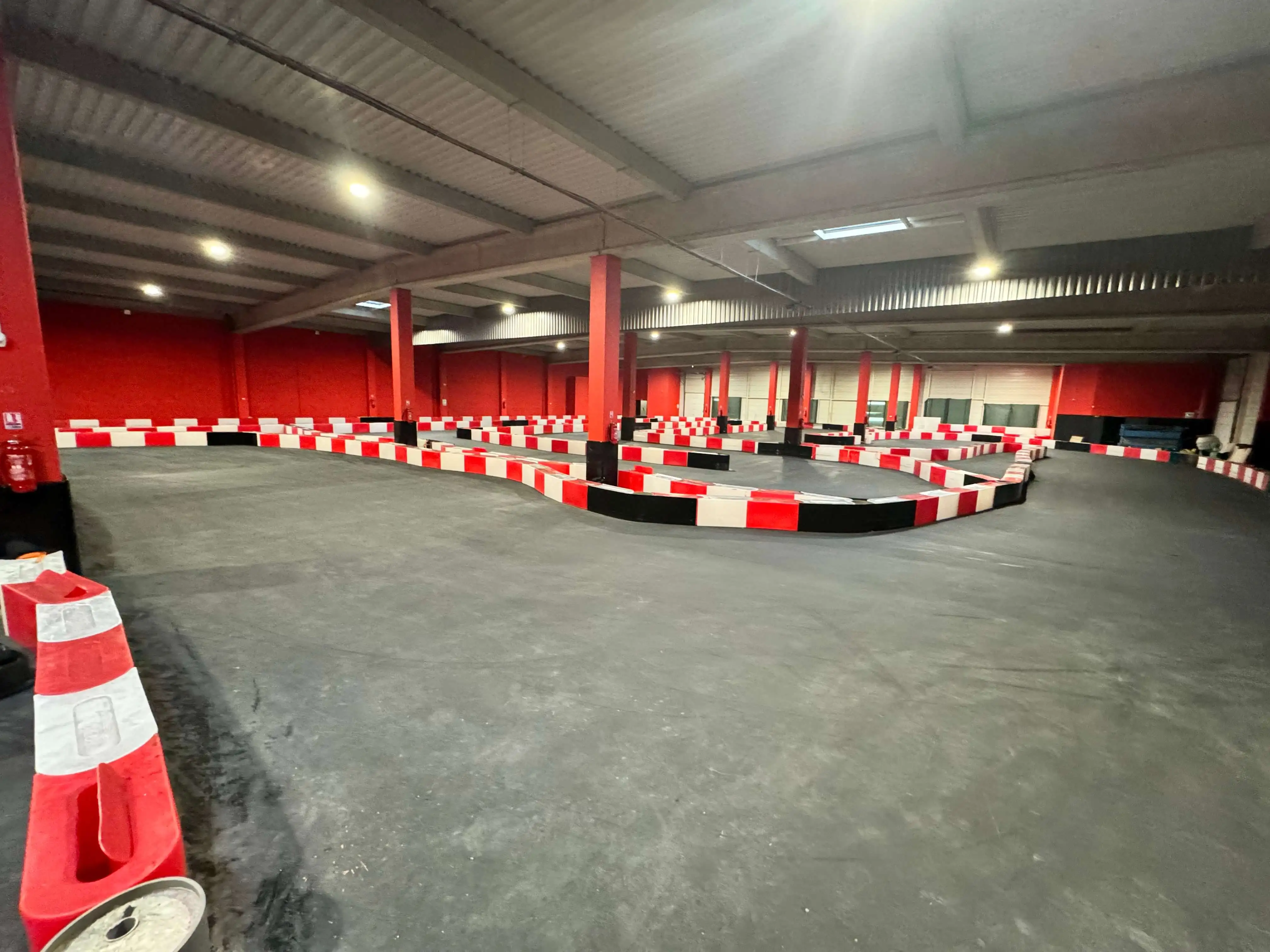 Vue panoramique de la piste de karting chez OumCityGames, avec virages serrés et lignes droites pour une expérience de course excitante